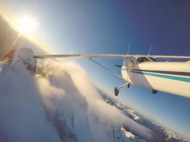 Rocky Candian Dağları yakınında canlı bir gün batımı sırasında uçan küçük uçak. Squamish Kuzey Vancouver, British Columbia, Kanada alınan.
