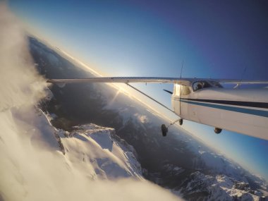 Rocky Candian Dağları yakınında canlı bir gün batımı sırasında uçan küçük uçak. Squamish Kuzey Vancouver, British Columbia, Kanada alınan.