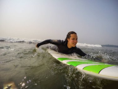 Kadın acemi sörfçü Pasifik Okyanusu'nda sörf yapmayı öğreniyor. Estevan, Vancouver Adası, British Columbia, Kanada alınan.
