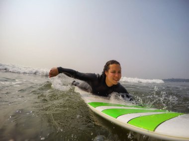 Kadın acemi sörfçü Pasifik Okyanusu'nda sörf yapmayı öğreniyor. Estevan, Vancouver Adası, British Columbia, Kanada alınan.