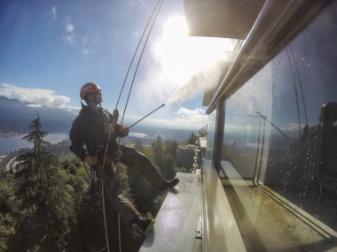 Burnaby, Vancouver, Bc, Kanada - 08 Temmuz 2018: Yüksek artış ip teknisyen hangining bina ve güç yıkama tarafında olan.