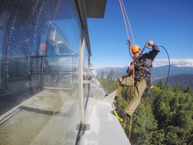 Burnaby, Vancouver, Bc, Kanada - 08 Temmuz 2018: Yüksek artış ip teknisyen hangining bina ve güç yıkama tarafında olan.