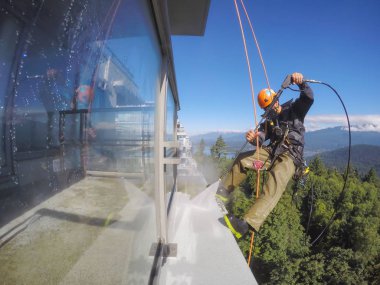 Burnaby, Vancouver, Bc, Kanada - 08 Temmuz 2018: Yüksek artış ip teknisyen hangining bina ve güç yıkama tarafında olan.