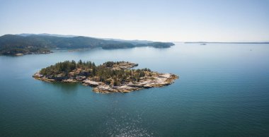 Hava panoramik bir kayalık ada bir canlı güneşli yaz gün boyunca. Powell Nehri, Sunshine Coast, British Columbia, Kanada.