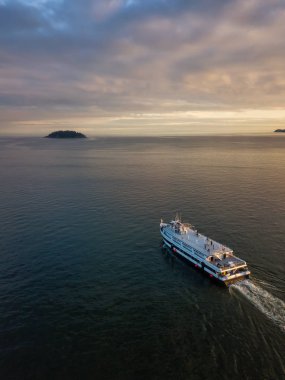 Bir feribot tekne okyanusa canlı bir bulutlu gün batımı sırasında hava görünümünü. Horseshoe Bay, Batı Vancouver, British Columbia, Kanada alınan.