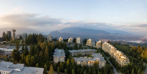 Aerial view of residential buildings on top of Burnaby Mountain during a vibrant sunset. Taken in Greater Vancouver, BC, Canada.