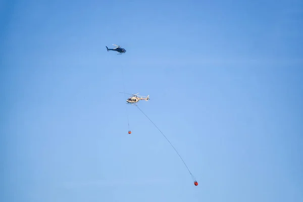 Helicopter fighting BC forest fires during a hot sunny summer day. Taken near Port Alice, Northern Vancouver Island, British Columbia, Canada.