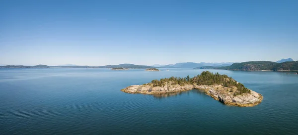 Aerial panoramic view of a rocky island during a vibrant sunny summer day. Taken near Powell River, Sunshine Coast, British Columbia, Canada.