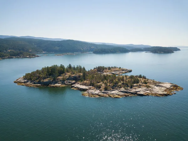 Aerial view of a rocky island during a vibrant sunny summer day. Taken near Powell River, Sunshine Coast, British Columbia, Canada.