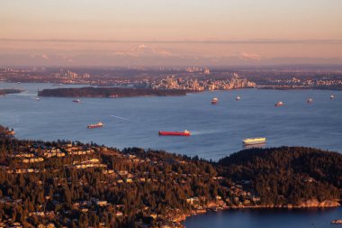 Canlı bir gün batımı sırasında Arka Planda Downtown City ile Horseshoe Bay havadan görünümü. Batı Vancouver, British Columbia, Kanada'da çekilmiş.