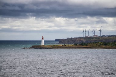 Bulutlu bir günde okyanus kıyısında rüzgar türbini. New Victoria, Nova Scotia, Kanada 'da çekildi.