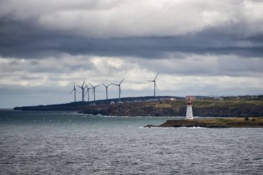 Bulutlu bir günde okyanus kıyısında rüzgar türbini. New Victoria, Nova Scotia, Kanada 'da çekildi.