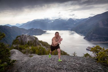 Fit ve Kaslı Genç Adam bulutlu bir gün boyunca Dağ kadar çalışıyor. Squamish'teki Chief Mountain'da alındı, Vancouver'ın kuzeyinde, Bc, Kanada.