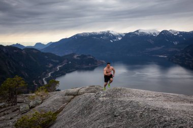 Fit ve Kaslı Genç Adam bulutlu bir gün boyunca Dağ kadar çalışıyor. Squamish'teki Chief Mountain'da alındı, Vancouver'ın kuzeyinde, Bc, Kanada.
