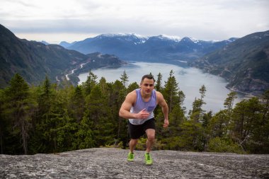 Fit ve Kaslı Genç Adam bulutlu bir gün boyunca Dağ kadar çalışıyor. Squamish'teki Chief Mountain'da alındı, Vancouver'ın kuzeyinde, Bc, Kanada.