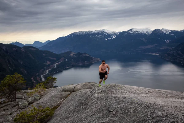 健身和肌肉的年轻人在阴天跑上山 拍摄于加拿大不列颠哥伦比亚省温哥华以北的斯夸米什头山 — 图库照片