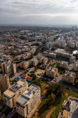 Bulutlu ve güneşli bir gün doğumu sırasında bir şehirde bir yerleşim mahallehavadan görünümü. Alınan Netanya, Center District, İsrail.