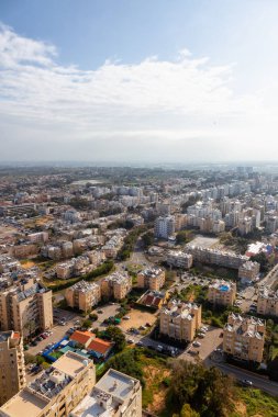Bulutlu ve güneşli bir gün doğumu sırasında bir şehirde bir yerleşim mahallehavadan görünümü. Alınan Netanya, Center District, İsrail.