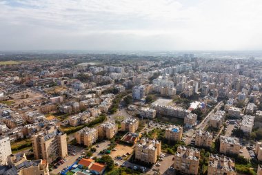Aerial view of a residential neighborhood in a city during a cloudy and sunny sunrise. Taken in Netanya, Center District, Israel. clipart