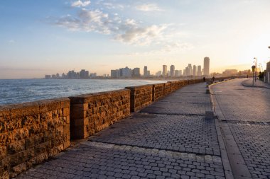 Güneşli bir gün doğumu sırasında okyanus kıyısında yan yürüyüş güzel bir görünüm. Yafa Old City, Tel Aviv, İsrail.