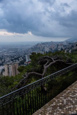 Bulutlu bir gün batımı sırasında Akdeniz kıyısında bir şehrin güzel görünümü. Hayfa, İsrail'de çekilmiş.
