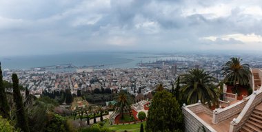 Bahai Bahçeleri ve bulutlu bir gün batımı sırasında Akdeniz kıyısında bir şehir güzel panoramik görünümü. Hayfa, İsrail'de çekilmiş.