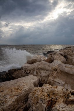 Bulutlu ve güneşli bir günde Akko Eski Şehir yakınlarındaki kayalık ve çamurlu kıyısında güzel bir görünüm. Acre, İsrail'de çekilmiş.