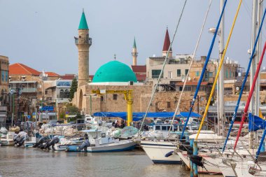 Acre, North District, İsrail - 1 Nisan 2019: Bulutlu ve güneşli bir günde Akko'nun Eski Şehir'indeki yat limanında teknelerin güzel görünümü.