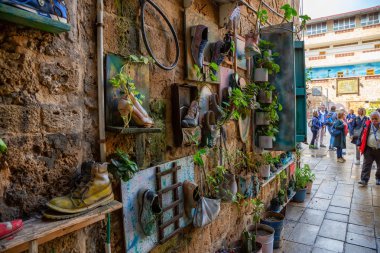 Acre, North District, İsrail - 1 Nisan 2019: Ayakkabı ve bitkiler Akko Eski Şehir tuğla duvara asılı.