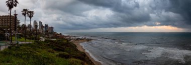 Bulutlu bir gün doğumu sırasında kumlu bir plaj güzel bir görünüm. Alınan Netanya, Center District, İsrail.