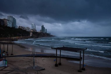 Netanya, İsrail'de fırtınalı bir gündoğumu sırasında Kumlu plaj.