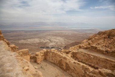 Bulutlu ve güneşli bir günde bir dağın tepesinde ki antik bir kalenin güzel manzarası. Alınan Masada Ulusal Parkı, İsrail.