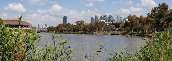 Beautiful panoramic view of a river in Yarkon Park during a vibrant sunny day. Taken in Tel Aviv, Israel.