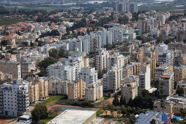 Aerial view of a residential neighborhood in a city during a cloudy and sunny day. Taken in Netanya, Center District, Israel.