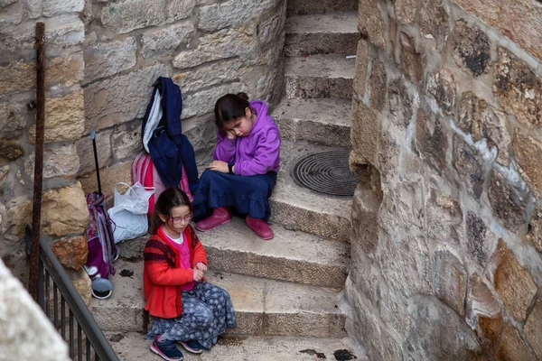 Kudüs, İsrail - 2 Nisan 2019: Eski Şehir'de merdivenlerde oturan sıkılmış çiftin havadan görünümü.