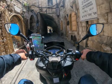 Kudüs, İsrail - 16 Nisan 2019: Bulutlu ve güneşli bir günde yoğun şehir sokaklarında scooter sürmek.