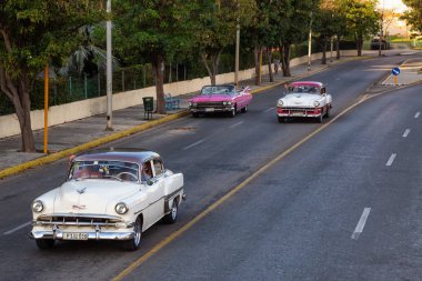 Varadero, Küba - 8 Mayıs 2019: Canlı güneşli bir akşamda sokakta sürüş Klasik Eski Taksi Aracı yukarıdan havadan görünümü.