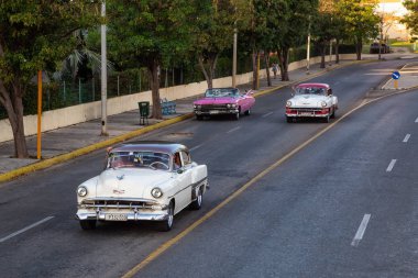 Varadero, Küba - 8 Mayıs 2019: Canlı güneşli bir akşamda sokakta sürüş Klasik Eski Taksi Aracı yukarıdan havadan görünümü.