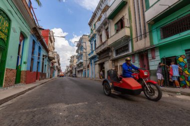 Havana, Küba - 14 Mayıs 2019: Eski Havana Şehrinin sokaklarında motosiklet sürme, Küba'nın başkenti, parlak ve güneşli bir günde.