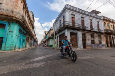 Havana, Küba - 14 Mayıs 2019: Eski Havana Şehrinin sokaklarında motosiklet sürme, Küba'nın başkenti, parlak ve güneşli bir günde.