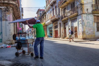 Havana, Küba - 13 Mayıs 2019: Canlı ve parlak güneşli bir sabahta Eski Havana Şehrinin sokaklarında su satan satıcı.
