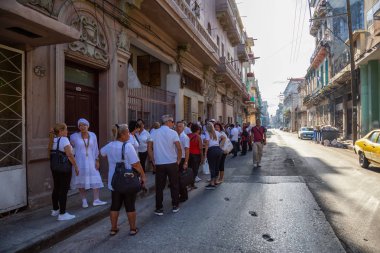 Havana, Küba - 13 Mayıs 2019: Parlak güneşli bir sabahta Eski Havana Şehrinin sokaklarında yemek için sırada bekleyen Kübalı lar.