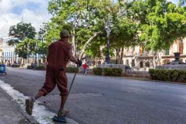 Havana, Küba - 13 Mayıs 2019: Sıcak güneşli bir sabahta Eski Havana Şehrinin sokaklarında işçi işi yapan, temizlik yapan adam.