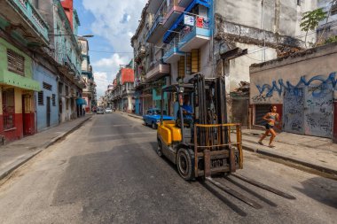 Havana, Küba - 14 Mayıs 2019: Canlı ve aydınlık güneşli bir günde Eski Havana Şehrinin sokaklarında Forklift kullanan adam.