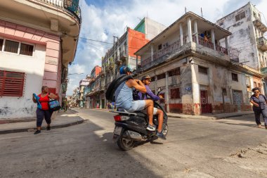 Havana, Küba - 14 Mayıs 2019: Parlak ve güneşli bir günde Küba'nın başkenti Eski Havana Şehrinin sokaklarında motosikletli Kübalı erkekler.