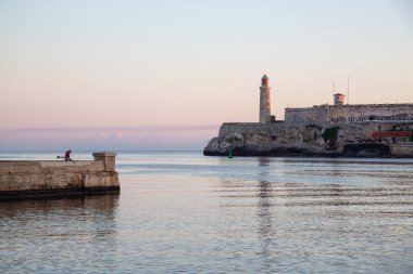Renkli ve güneşli bir gün doğumu sırasında, Küba'nın başkenti Eski Havana'daki Deniz Feneri'nin güzel manzarası.