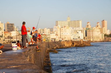 Havana, Küba - 21 Mayıs 2019: Küba halkı, Gıda Krizi Kıtlığı sırasında çekilen güneşli bir sabah gündoğumu sırasında okyanusta balık tutuyor.