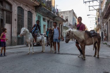 Havana, Küba - 27 Mayıs 2019: Eski Havana Şehrinin sokaklarında küçük bir atla genç Kübalı çocuklar, Küba'nın başkenti, parlak ve güneşli bir akşam.