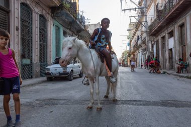 Havana, Küba - 27 Mayıs 2019: Eski Havana Şehrinin sokaklarında küçük bir atla genç Kübalı çocuklar, Küba'nın başkenti, parlak ve güneşli bir akşam.