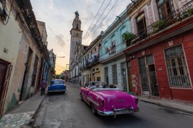 Havana, Küba - 17 Mayıs 2019: Klasik Eski Amerikan Arabası, canlı bir gün batımı nda Eski Havana Şehrinin sokaklarında.